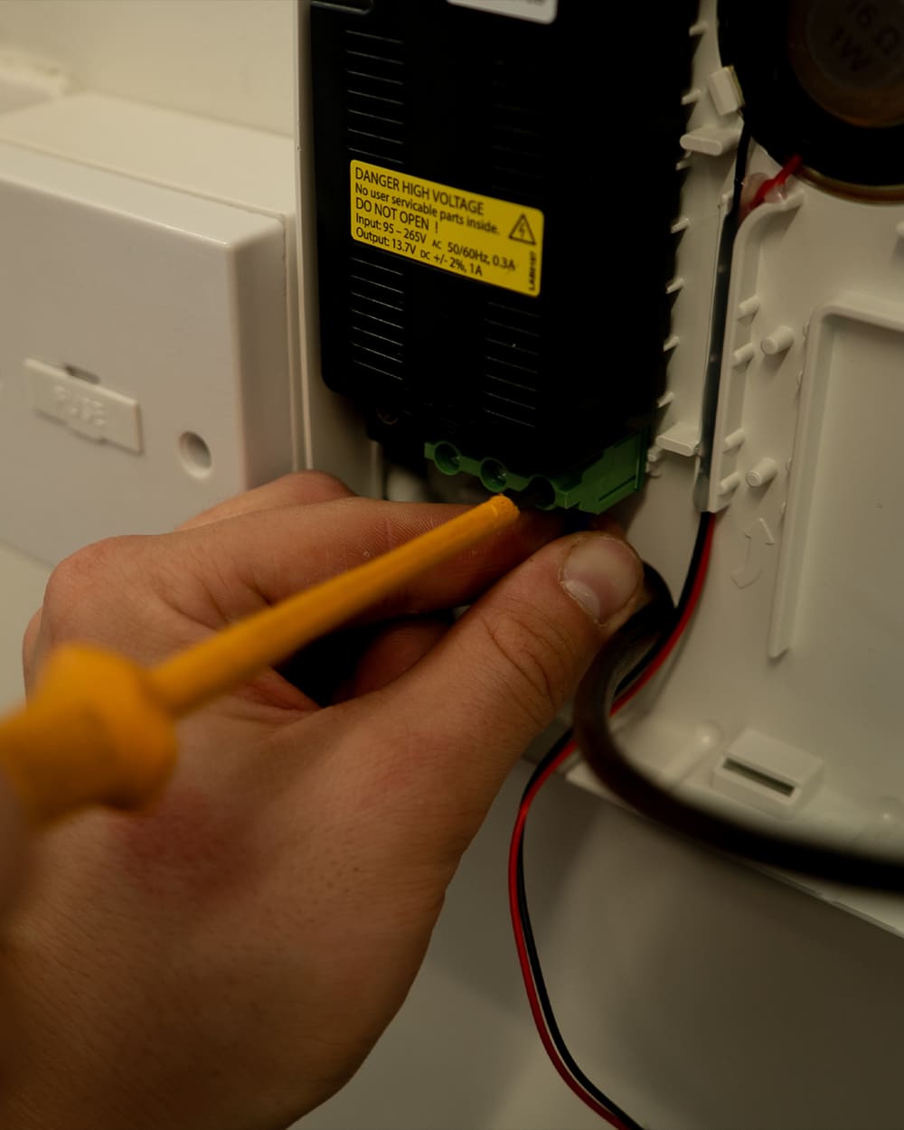 Engineer servicing an alarm power supply unit